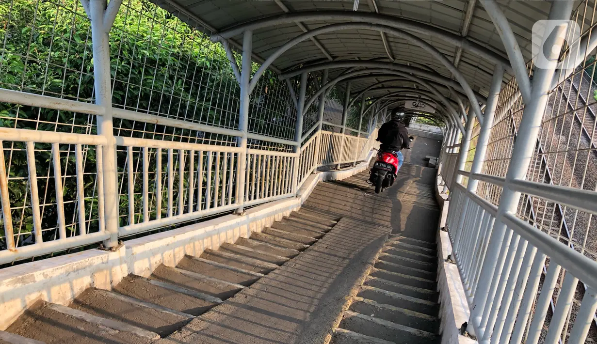 Pengendara sepeda motor melintasi Jembatan Penyeberangan Orang (JPO) di kawasan Pasar Minggu, Jakarta, Jumat (17/7/2020). Rendahnya kesadaran dalam disiplin berkendara menyebabkan sejumlah pengendara sepeda motor melintasi JPO tersebut meski merugikan pengguna lain. (Liputan6.com/Immanuel Antonius)