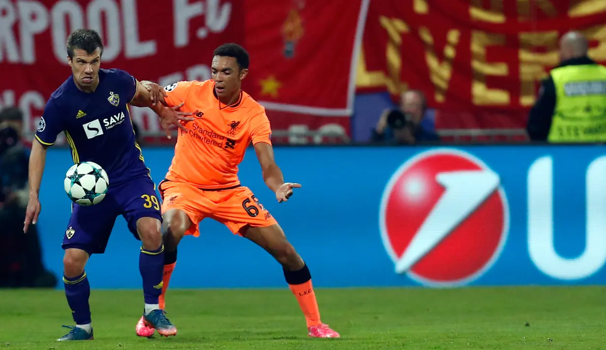 Pemain Liverpool, Trent Alexander-Arnold berebut bola dengan pemain Maribor, Damjan Bohar dalam lanjutan fase Grup E Liga Champions di Stadion Ljudski Maribor, Selasa (17/10). Liverpool berhasil pesta gol 7-0 di markas lawannya itu. (AP/Darko Bandic)