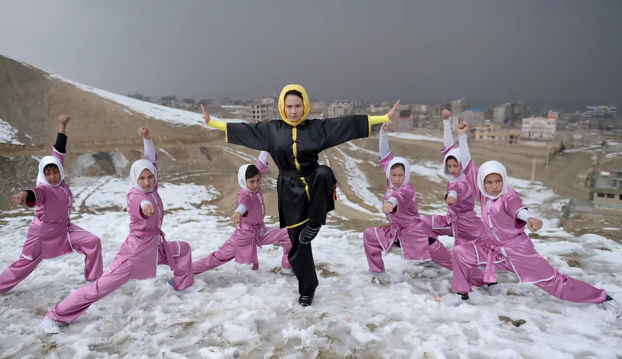 Sima Azimi (tengah) berpose bersama anggota kelompok seni bela diri Wushu Afghanistan di puncak bukit Shahrak Haji Nabi, Kabul, 29 Januari 2017. Sima Azimi adalah wanita pertama dari Afghanistan yang menjadi pelatih seni bela diri Wushu (WAKIL KOHSAR/AFP)