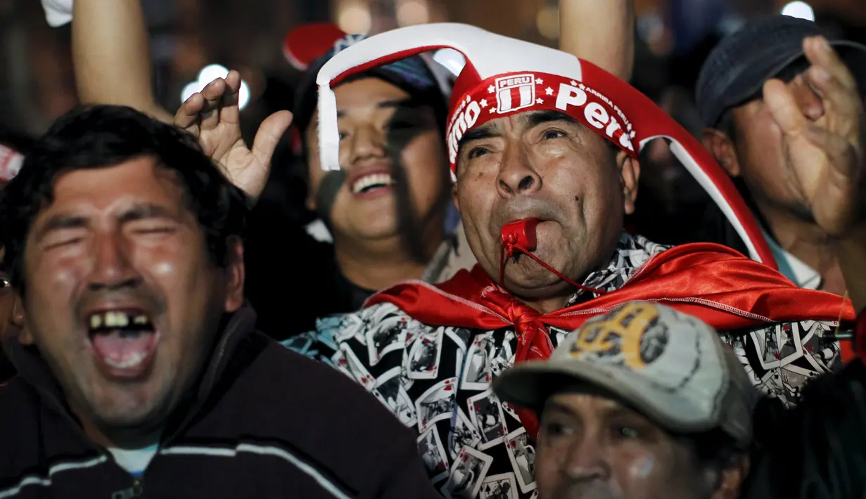 Seorang suporter Peru meniupkan peluit saat menyaksikan pertandingan perempat final Peru melawan Bolivia di Copa America 2015 di pusat kota Lima, Peru, (26/6/2015) dini hari. Peru melangkah ke semifinal usai mengalahkan Bolivia 3-1. (REUTERS/Janine Costa)
