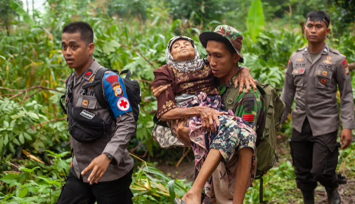 Tim SAR menggendong seorang wanita tua ke tempat aman setelah tanah longsor melanda di Gowa, Sulawesi Selatan, Jumat (25/1). Hingga 25 Januari 2018, tercatat 33 orang meninggal dunia. (YUSUF WAHIL/AFP)