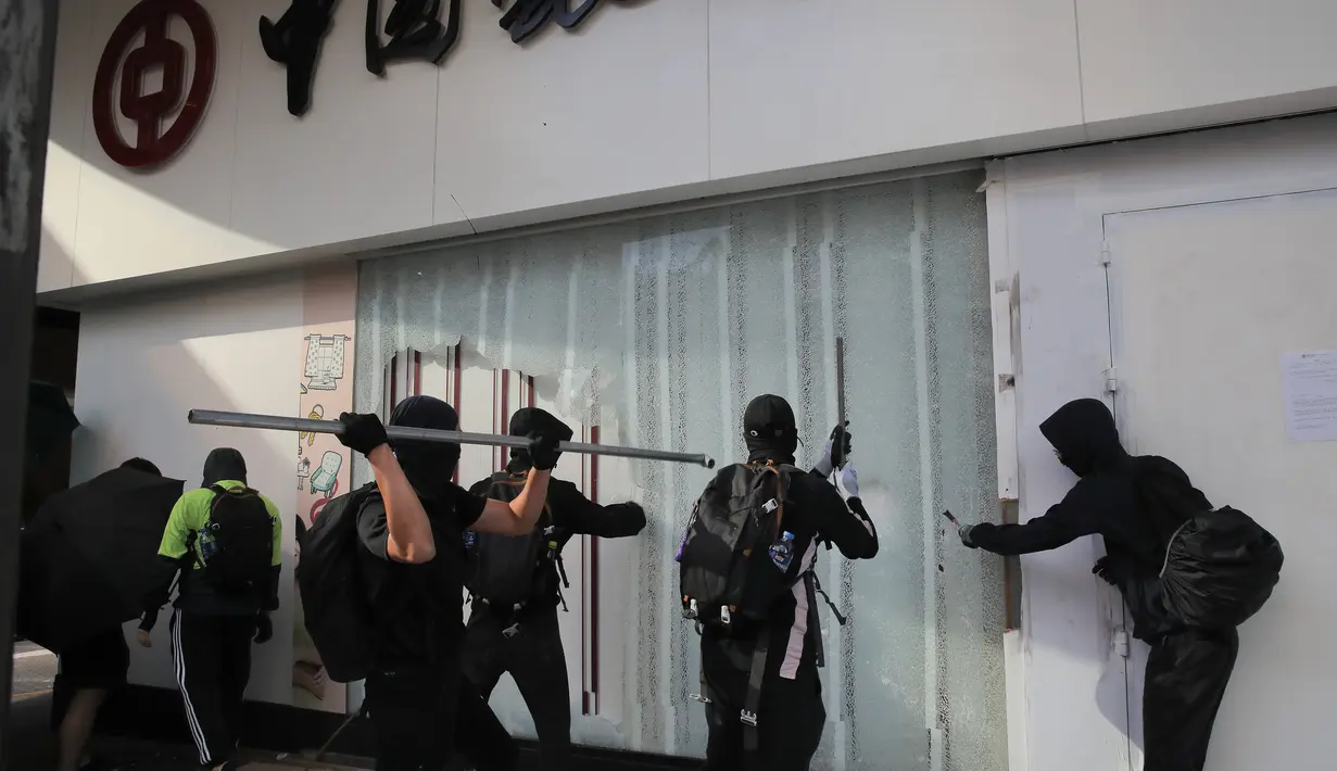 Demonstran merusak cabang Bank of China di Distrik Central, Hong Kong, Senin (11/11/2019). Ketegangan di Hong Kong semakin meningkat setelah polisi menembak seorang demonstran hingga kritis. (AP Photo/Kin Cheung)