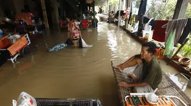 Seorang pria duduk di ranjang bambu saat banjir menyusul hujan di pinggiran Phnom Penh, Kamboja (14 /10/2020). Pejabat bencana Kamboja mengatakan Rabu bahwa lebih dari 10.000 orang telah dievakuasi ke tempat aman setelah badai tropis melanda yang menyebabkan banjir bandang.  (AP Photo/Heng Sinith)