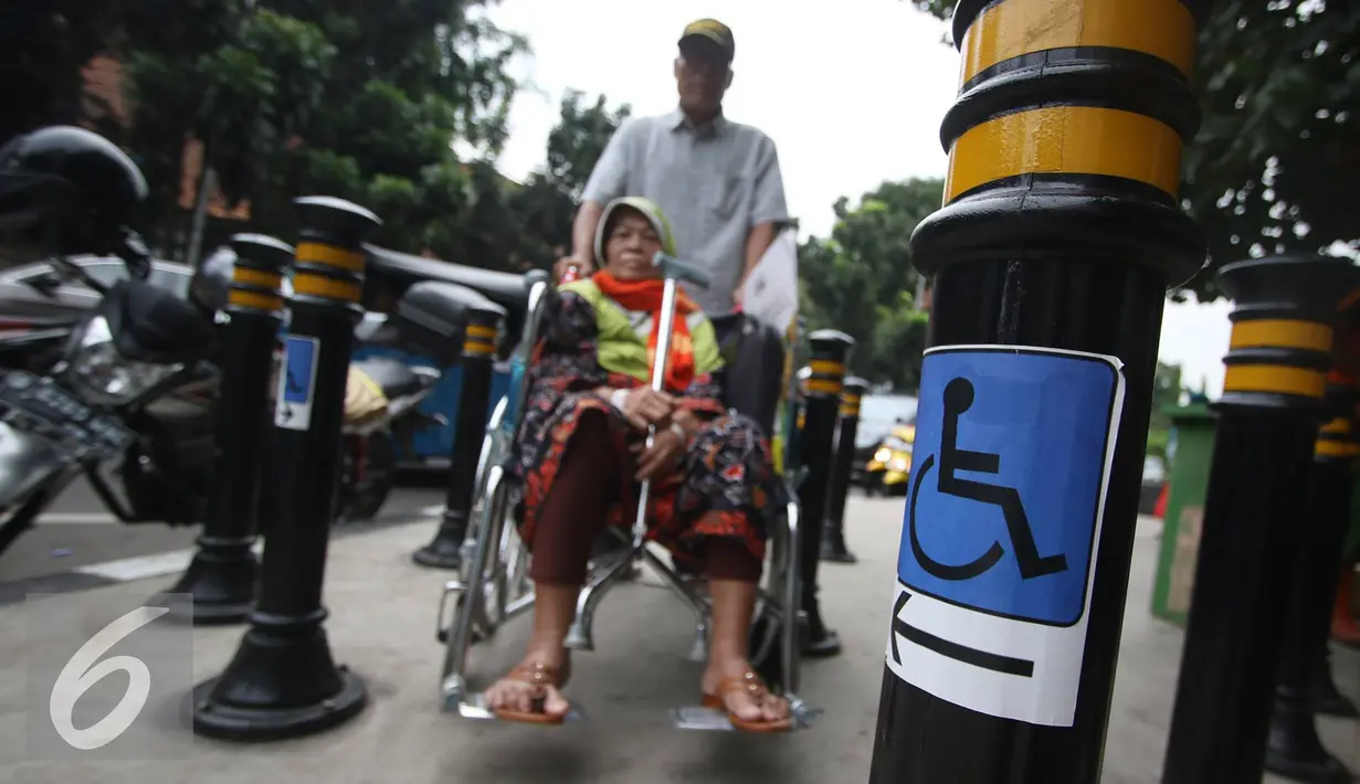 Lansia berkursi roda melintasi Portal S Ramah Disabilitas di trotoar RSCM, Jakarta, Jumat (26/8). Selain ramah disabilitas dan Lansia, portal tersebut juga berfungsi untuk mencegah sepeda motor masuk ke jalur trotoar. (Liputan6.com/Immanuel Antonius)