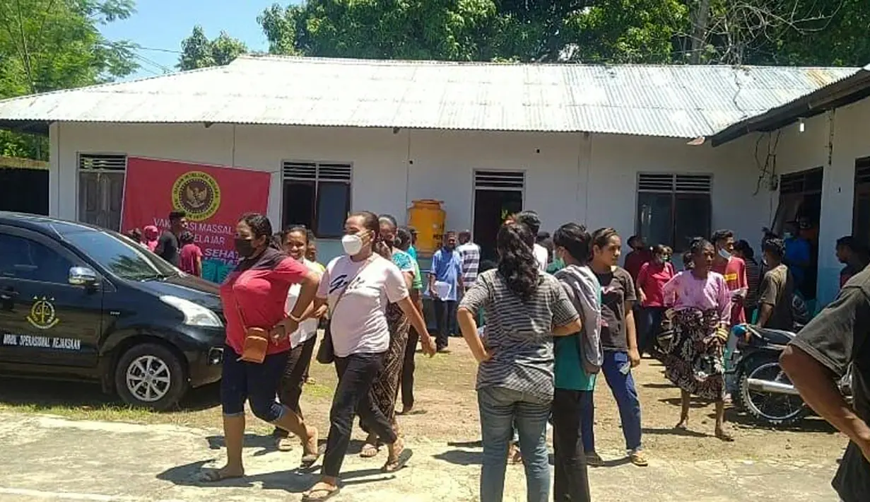Penduduk desa berdiri di luar sebuah gedung setelah gempa bumi berkekuatan 7,3 SR mengguncang lepas pantai di Maumere di Nusa Tenggara Timur di pulau Flores, Selasa (14/12/2021). (AFP/Yanuarius Arlino Welianto)