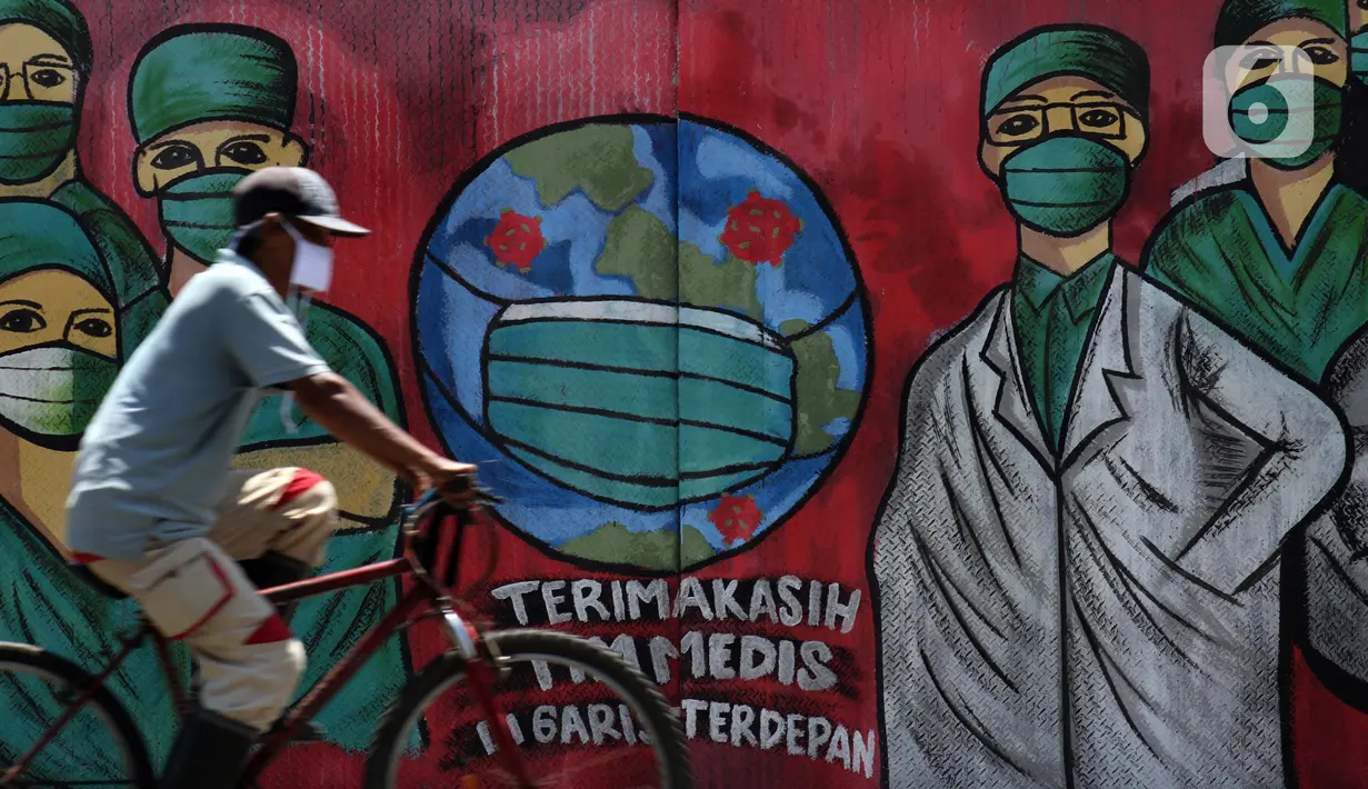 Pesepeda melintas di depan mural tentang pandemi virus COVID-19 di Jalan Raya Jakarta-Bogor, Depok, Selasa (7/4/2020). Mural tersebut ditujukan sebagai bentuk dukungan kepada tenaga medis yang menjadi garda terdepan menghadapi COVID-19 di Indonesia. (Liputan6.com/Helmi Fithriansyah)