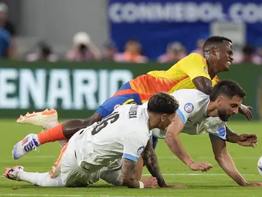 Gelandang Kolombia Jhon Arias (atas) berebut bola dengan pemain Uruguay Mathias Olivera dan rekan setimnya Rodrigo Bentancur pada partai semifinal  Copa America 2024 di Stadion Bank of America, Charlotte, Amerika Serikat, Kamis (11/7/2024). (AP Photo/Julia Nikhinson)