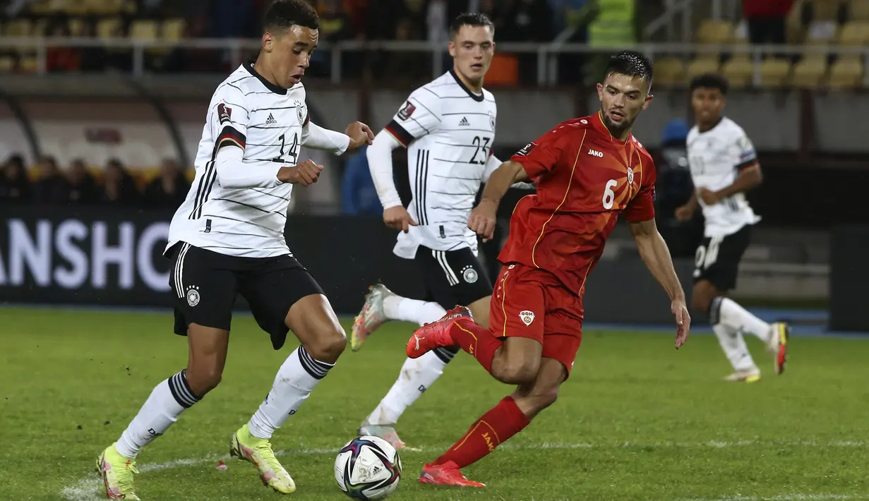 Gelandang Jerman Jamal Musiala (kiri) mencetak gol keempat untuk timnya ke gawang Makedonia Utara pada lanjutan Kualifikasi Piala Dunia 2022 zona Eropa Grup J di Tose Proeski National Arena, Selasa (12/10/2021) WIB. Jerman menghajar Makedonia Utara empat gol tanpa balas. (AP Photo/Boris Grdanoski)