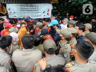 Orangtua murid menghadang pasukan Satpol PP yang hendak mengosongkan bangunan SDN Pondok Cina 1, Depok, Jawa Barat, Minggu (11/12/2022).  Pengosongan SDN Pondok Cina 1, yang akan dijadikan Masjid Raya Depok, oleh puluhan personel Satpol PP kota Depok pada Minggu pagi diwarnai ketegangan. (merdeka.com/Arie Basuki)