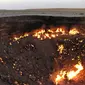 Gambar yang diambil pada 3 Mei 2014, menunjukkan orang-orang mengunjungi "Gerbang Neraka", sebuah kawah gas besar yang terbakar di jantung gurun Karakum Turkmenistan. (IGOR SASIN / AFP)