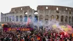 Bus tim AS Roma melaju di tengah kerumunan pendukung yang bergembira saat merayakan kemenangan juara Liga Konferensi Eropa UECL di depan Colosseum di Roma (26/5/2022). AS Roma menjuarai Konferensi Eropa UECL setelah mengalahkan Fayenoord dengan skor tipis 1-0. (AP Photo/Gregorio Borgia)