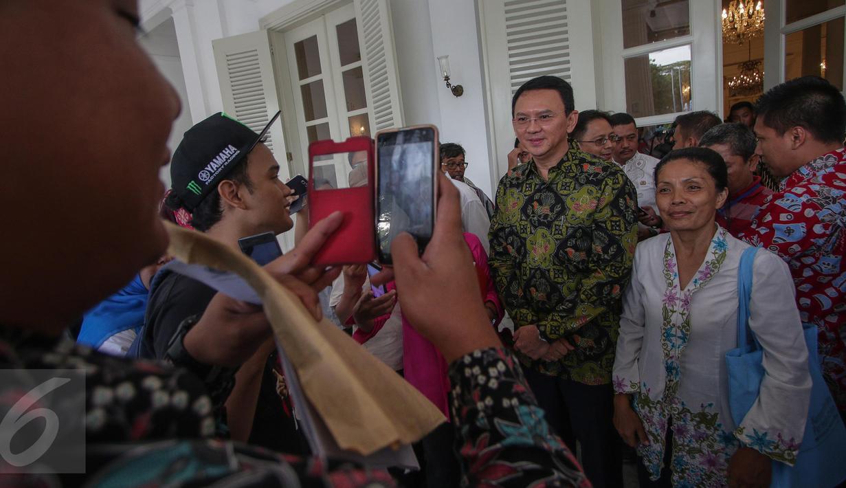 Gubernur DKI Basuki Tjahaja Purnama atau Ahok berfoto bersama warga di Balai Kota Jakarta, Kamis (20/4). Hari pertama setelah pemungutan suara Pilkada DKI, Ahok tetap ke Balai Kota untuk mendengarkan aduan warga. (Liputan6.com/Faizal Fanani)