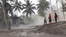 Tim penyelamat mencari korban di daerah yang terkena dampak letusan Gunung Semeru di Lumajang, Jawa Timur, Indonesia, Minggu (5/12/2021). Sumber BPBD Jawa Timur melaporkan, semeru mengeluarkan awan panas yang turun mengarah Curah Kobokan. (AP Photo/Rokhmad)