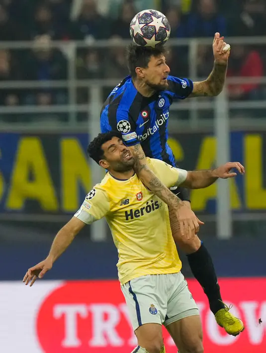 Pemain Inter Milan Francesco Acerbi (atas) bersaing memperebutkan bola dengan pemain Porto Mehdi Taremi pada pertandingan sepak bola leg pertama babak 16 besar Liga Champions di Stadion San Siro, Milan, Italia, 22 Februari 2023. Inter Milan mengalahkan Porto dengan skor 1-0. (AP Photo/Luca Bruno)