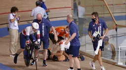 Pembalap Belanda Laurine van Riessen (tengah) menerima perawatan medis setelah bertabrakan dengan Katy Marchant dari Inggris (kiri) saat pertandingan babak perempat final Keirin Putri Balap Sepeda Trek Olimpiade Tokyo 2020 di Izu Velodrome di Izu, Jepang, Kamis (4/8/2021). (Odd ANDERSEN/AFP)