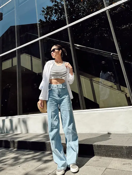Style kasual yang modis, bisa padukan striped crop tank top dengan kemeja putih dan high waisted jeans. [Instagram/azizahsalsha_]