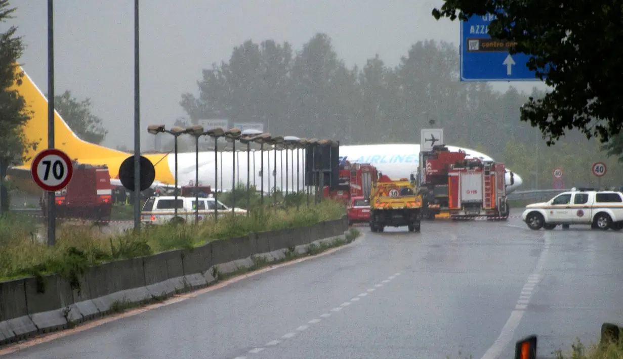 Pesawat kargo DHL menerobos pembatas jalan raya usai gagal mendarat di Orio al Serio, Milan, Italia (5/8). Pesawat ini hanya berisi tiga kru, yang semuanya selamat. (REUTERS)