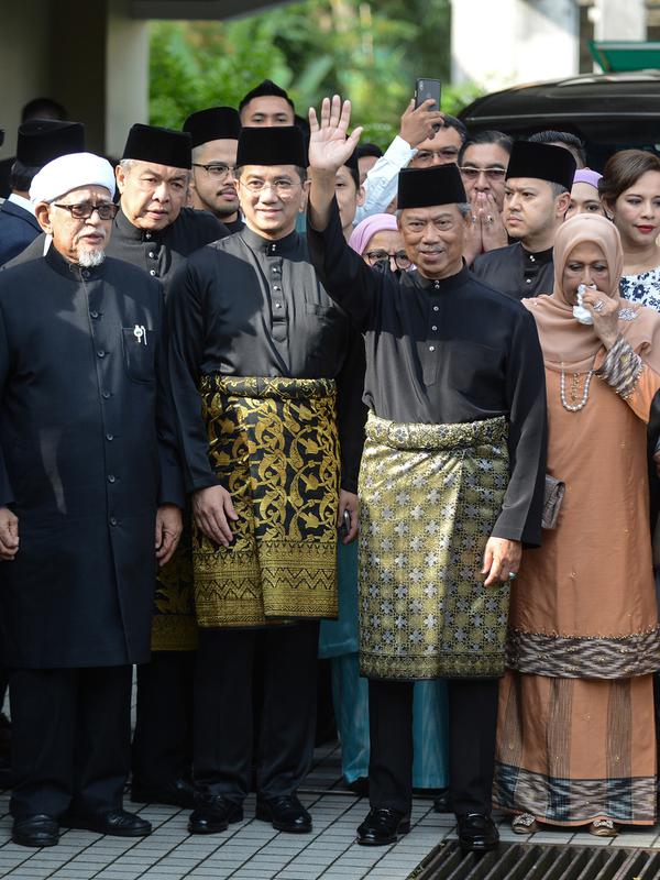 Muhyiddin Yassin (kedua kanan) melambaikan tangan sebelum upacara pelantikannya sebagai Perdana Menteri Malaysia di Istana Negara, Kuala Lumpur, Minggu (1/3/2020). Pelantikan dilakukan dengan alasan kursi kepemimpinan harus segera terisi. (NAZRI RAPAAI/AFP/MALAYSIA'S DEPARTMENT OF INFORMATION)