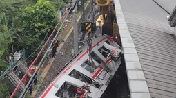 Proses evakuasi gerbong Kereta Rel Listrik (KRL) Commuter Line pasca-tabrakan Kereta Api Jarak Jauh (KAJJ) Argo Bromo Anggrek relasi Gambir-Surabaya Pasar Turi di Stasiun Bekasi Timur, Bekasi, Jawa Barat, Selasa (28/4/2026). (merdeka.com/Arie Basuki)