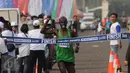 Pelari Kenya, Geoffrey Kipcrotich Birgen mengangkat tangan saat finis pertama di lomba lari Jakarta Marathon 2015 di Silang Monas Jakarta, Minggu (25/10/2015). Geoffrey mencatat waktu dua jam 17 menit 38 detik. (Liputan6.com/Helmi Fithriansyah)