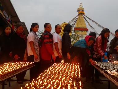 Umat Buddha Nepal berbaris untuk menyalakan lilin saat perayaan Buddha Jayanti atau Buddha purnima di stupa Boudhanath, Kathmandu, Nepal (30/4). (AP/Niranjan Shrestha)