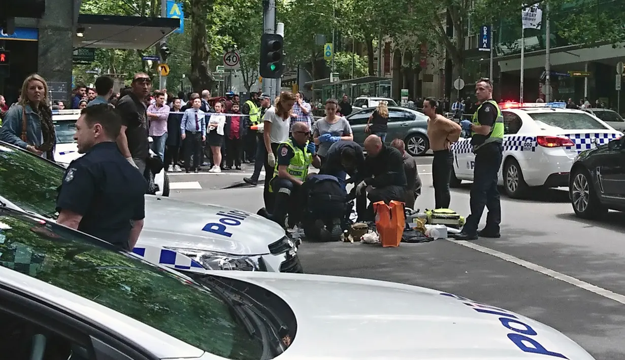 Polisi dan tim medis dikerahkan ke lokasi dimana sebuah mobil menghantam para pejalan kaki di pusat kota Melbourne, Australia, Jumat (20/1). Tiga orang tewas dan 20 orang lainnya luka-luka dalam insiden itu. (Luke Costin/AAP via AP)