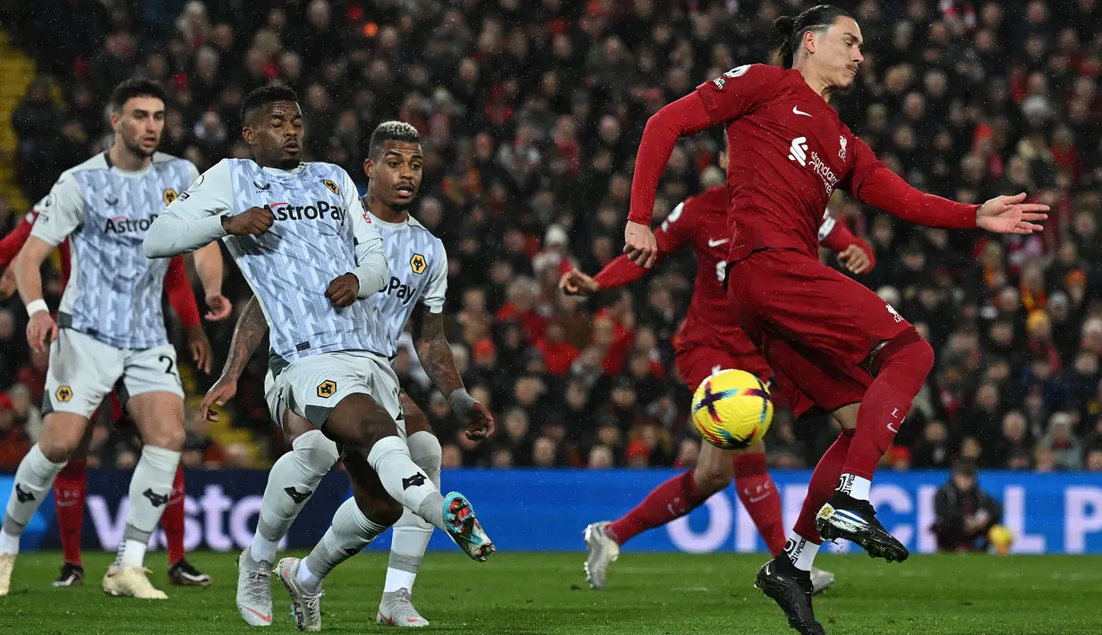 Striker Liverpool Darwin Nunez (kanan) melakukan tembakan ke gawang Wolverhampton Wanderers Ruben Neves pada laga tunda Liga Inggris pekan ke-7 di Anfield, Rabu (2/3/2023) dini hari WIB. Liverpool yang menjamu Wolverhampton Wanderers di Anfield sempat kesulitan. (Paul ELLIS / AFP)