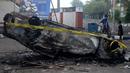 Mobil dibakar di luar Stadion Kanjuruhan, Malang, Jawa Timur, Minggu (2/10/2022). Sebanyak 127 orang tewas ketika para penggemar yang marah menyerbu lapangan sepak bola setelah pertandingan antara Arema FC dan Persebaya Surabaya pada 1 Oktober 2022. (PUTRI/AFP)