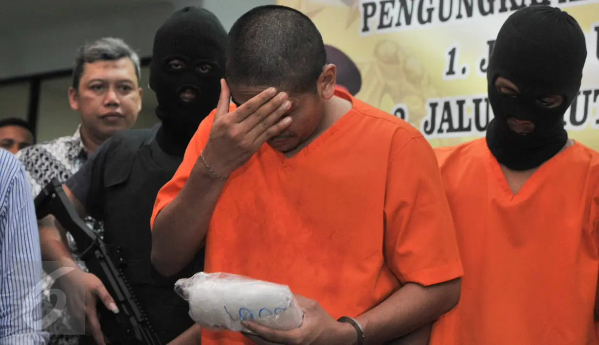 Salah satu tersangka diperlihatkan petugas saat Press Release di kantor Bareskrim Cawang, Jakarta, Selasa (7/3). Bareskrim berhasil mengungkap kasus peredaran narkotika jaringan internasional Malaysia-Indonesia. (Liputan6.com/Yoppy Renato)