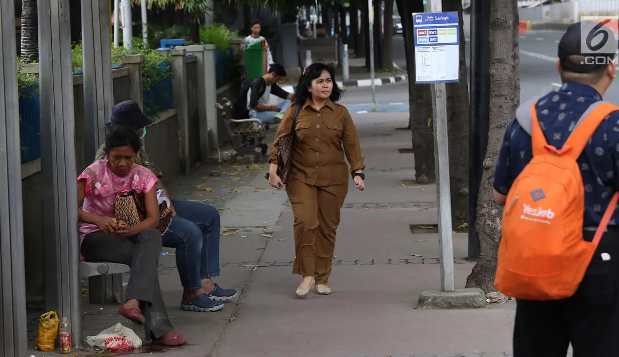 Seorang wanita berjalan di atas trotoar kawasan MH Thamrin, Jakarta, Selasa (6/3). Pemerintah Provinsi (Pemprov) DKI Jakarta mulai merencanakan penataan jalan dan trotoar di sepanjang Jalan Sudirman dan Jalan MH Thamrin. (Liputan6.com/Immanuel Antonius)