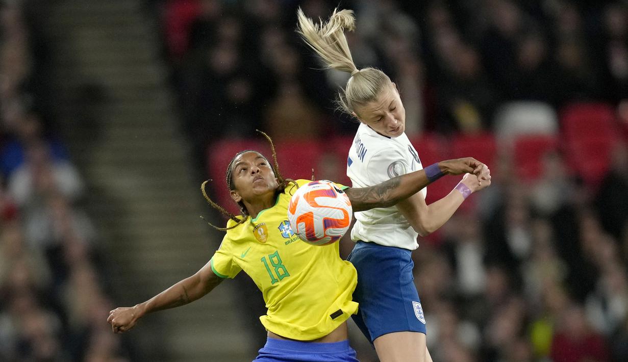 Pemain Timnas Inggris, Leah Williamson (kanan) berebut bola dengan pemain Timnas Brasil, Geyse pada laga Finalisima Putri 2023 di Stadion Wembley, London, Jumat (07/04/2023) WIB. The Three Lions secara dramatis mengalahkan Brasil dengan skor 4-2 dalam babak adu penalti setelah bermain imbang 1-1 di waktu normal. (AP Photo/Kirsty Wigglesworth)