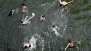 Warga berenang untuk mendinginkan diri pada hari yang panas dan lembab selama bulan suci Ramadan di pinggiran Kairo, Mesir, Sabtu (18/5/2019). (REUTERS/Mohamed Abd El Ghany)