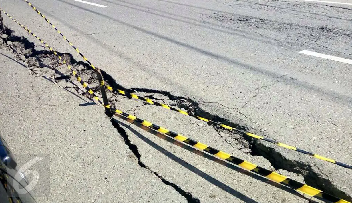 Kondisi jalan retak di Kabupaten Pidie Jaya, Aceh, Kamis (8/12). Gempa berkekuatan 6,5 SR pada Rabu pagi menyebabkan sejumlah ruas jalan retak dan mengalami kerusakan. (Liputan6.com/Angga Yuniar)