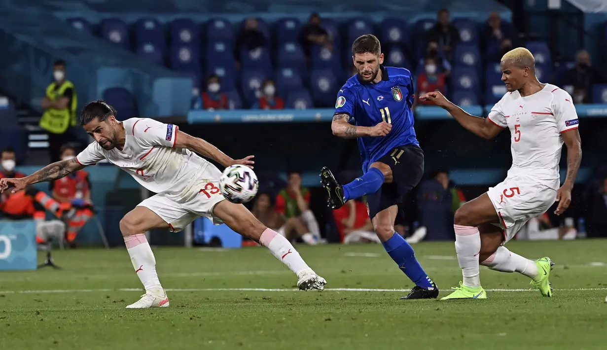 Penyerang Italia, Domenico Berardi menembak bola dari kawalan bek Swiss, Ricardo Rodriguez dan Manuel Akanji selama pertandingan grup A Euro di stadion Olimpiade di Roma, Rabu (16/6/2021). Dengan hasil ini, Italia kokoh dipuncak klasemen dengan poin enam. (Andreas Solaro/Pool Photo via AP)