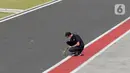 Salah satu official tim mengukur suhu aspal sekitar pit lane saat sesi Warm Up MotoGP di Pertamina Mandalika International Street Sirkuit, Nusa Tenggara Barat, Minggu (20/3/2022). (Liputan6.com/Helmi Fithriansyah)