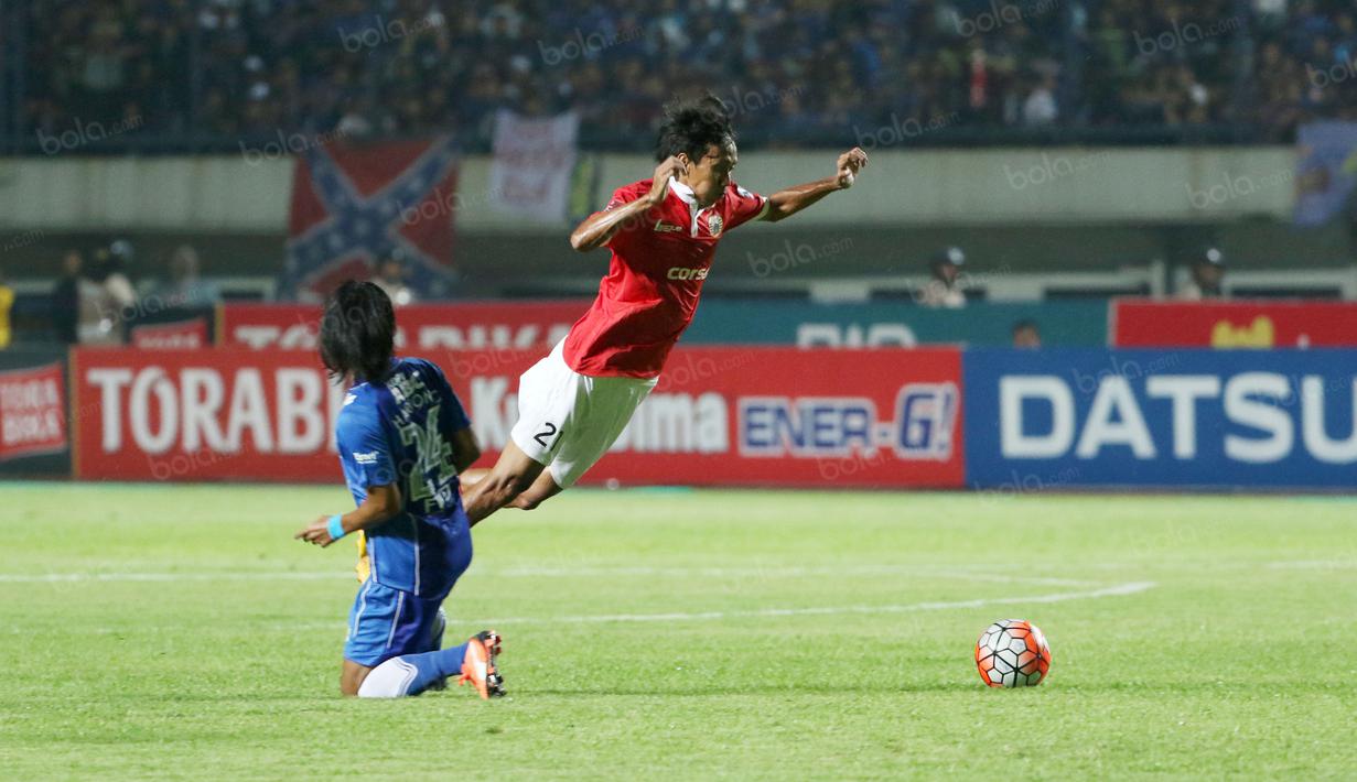 Pemain Persija, Amarzukih (kanan) menghindar dari hadangan pemain Persib Bandung, Haryono pada laga Torabika SC 2016 di Stadion Gelora Bandung Lautan Api, Bandung, Sabtu (16/7/2016). (Bola.com/Nicklas Hanoatubun)