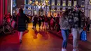 Orang-orang yang memakai masker berjalan di pusat kota Madrid, Rabu (22/12/2021). Perdana Menteri Spanyol Pedro Sanchez mengadakan rapat Kabinet khusus untuk mengesahkan undang-undang yang mewajibkan penggunaan masker di luar ruangan di tengah lonjakan rekor kasus COVID-19. (AP Photo/Manu Fernandez)