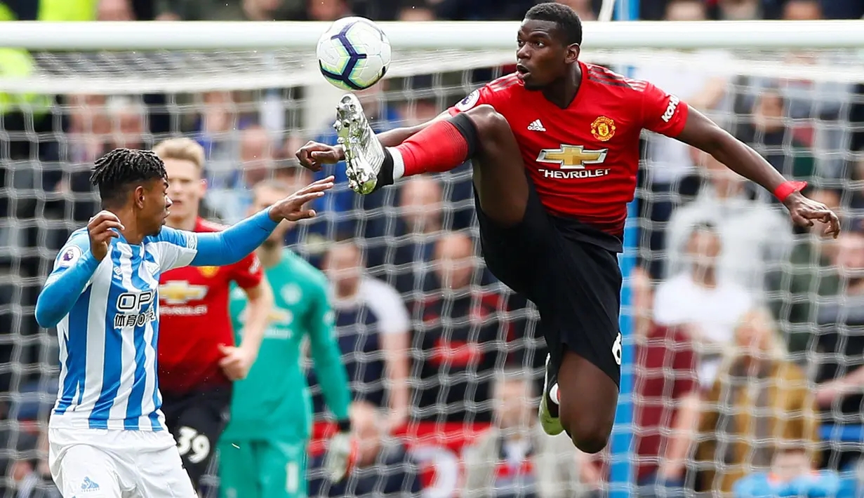 Gelandang Manchester United, Paul Pogba berebut bola dengan pemain Huddersfield Town, Junders Bacuna pada pekan ke-37 Liga Inggris di John Smith's Stadium, Minggu (5/5/2019). MU gagal ke Liga Champions musim depan setelah ditahan Huddersfield Town dengan skor 1-1. (REUTERS/Peter Powell)