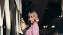 Angèle tampil bak barbie dengan setelan knit cardigan dan shorts nuansa pink-hijau yang fun dan playful. Ia melengkapi penampilannya dengan mini bag warna senada. [Dok/Chanel].