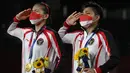 Pasangan Indonesia, Apriyani Rahayu (kanan) dan Greysia Polii Indonesia memberi hormat dengan medali emas bulu tangkis ganda putri pada upacara selama Olimpiade Tokyo 2020 di Musashino Forest Sports Plaza di Tokyo pada 2 Agustus 2021.
(AFP/Alexander Nemenov)