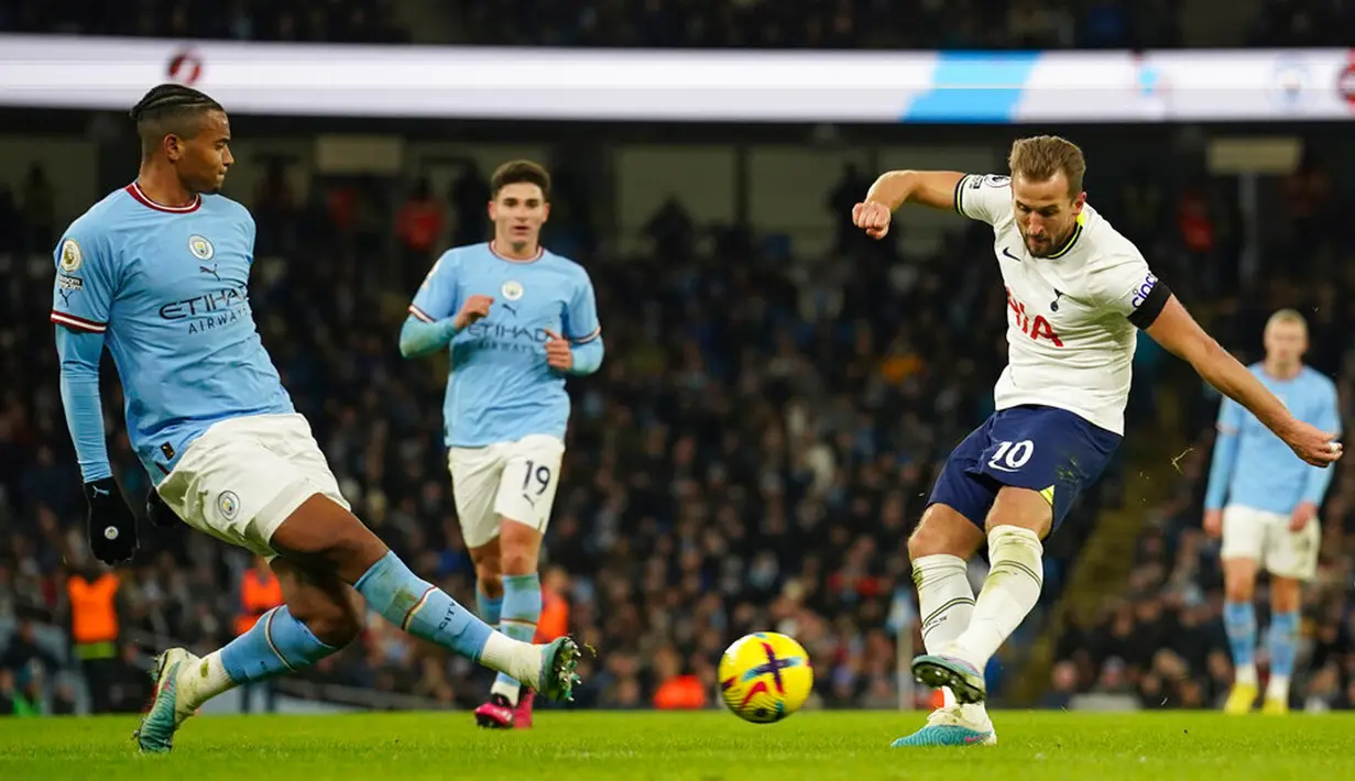 Pemain Tottenham Hotspur Harry Kane (kanan) menendang bola ke gawang di depan pemain Manchester City Manuel Akanji pada pertandingan sepak bola Liga Inggris di Etihad Stadium, Manchester, Inggris, 19 Januari 2023. Manchester City mengalahkan Tottenham Hotspur dengan skor 4-2. (AP Photo/Dave Thompson)