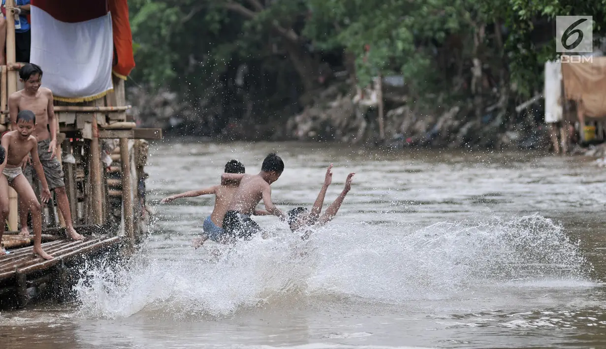 Keceriaan anak-anak saat berenang di Kali Ciliwung, Bukit Duri, Jakarta, Kamis (12/4). Relokasi bangunan liar di sekitar kali nantinya bakal dilakukan untuk mengembalikan fungsinya. (Merdeka.com/Iqbal Nugroho)
