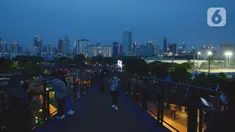 Pengunjung menikmati pemandangan dari Skywalk Senayan Park, Jakarta, Rabu (29/12/2021). Kawasan yang menyajikan pemandangan lanskap perkotaan itu menjadi alternatif destinasi wisata Jakarta yang instagramble dengan spot foto yang beragam. (merdeka.com/Imam Buhori)
