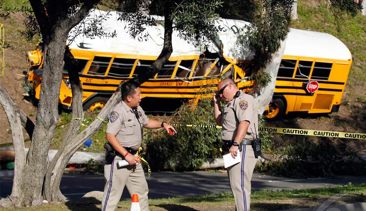 Petugas berdiskusi dengan rekannya di lokasi tempat terjadinya kecelakaan bus sekolah, Anaheim, California, Kamis (24/04/2014)(REUTERS/Alex Gallardo).