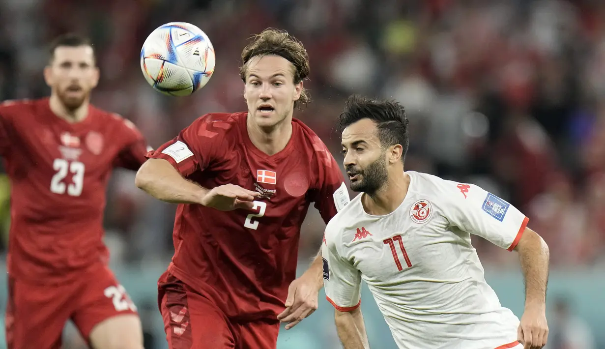Pemain Denmark, Joachim Andersen berebut bola dengan pemain Tunisia, Taha Yassine Khenissi selama pertandingan grup D Piala Dunia 2022 Qatar di Education City Stadium di Al Rayyan, Qatar, Selasa (22/11/2022). Dengan demikian, kedua tim sama-sama mengumpulkan satu poin di Grup D. (AP Photo /Hasan Ammar)