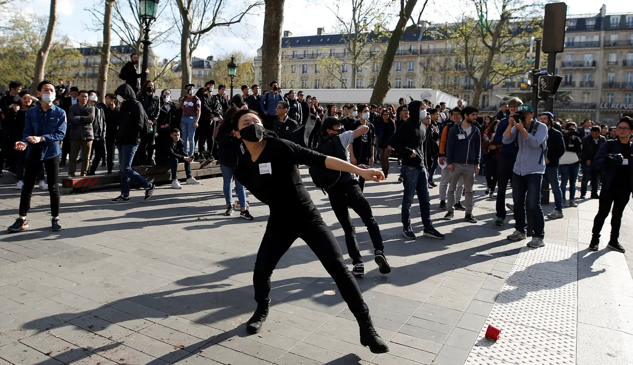 Sejumlah demonstran melempari petugas saat bentrokan terjadi di Place de la Republique, di Paris, Prancis (2/4). Mereka menggelar aksi terkait insiden pria China yang ditembak mati polisi, akhir Maret lalu. (AFP/Benjamin Cremel)