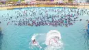 Suasana foto udara warga China bersantai di kolam renang Lianyungang, provinsi Jiangsu timur, China (4/7/2021). Di tengah pandemi Covid-19, warga China asyik menonton pertunjukan papan luncur saat mereka mendinginkan diri di kolam renang sambil bersantai. (AFP/STR)