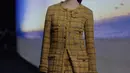 Margaret QUALLEY, CHANEL Ambassador, mengenakan coat tweed berwarna kuning, dengan rok kulot senada, look 12, dari koleksi CHANEL Métiers d’Art 2023/24. Aksesoris, tas dan sepatu CHANEL.  [Foto: Chanel.dok]