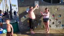 Anggota keluarga mendinginkan diri dengan mandi di pancuran luar ruangan di Venice Beach, Los Angeles, Amerika Serikat, Selasa (24/7). Panas ekstrem menyebar di seluruh Southwest. (AP Photo/Richard Vogel)