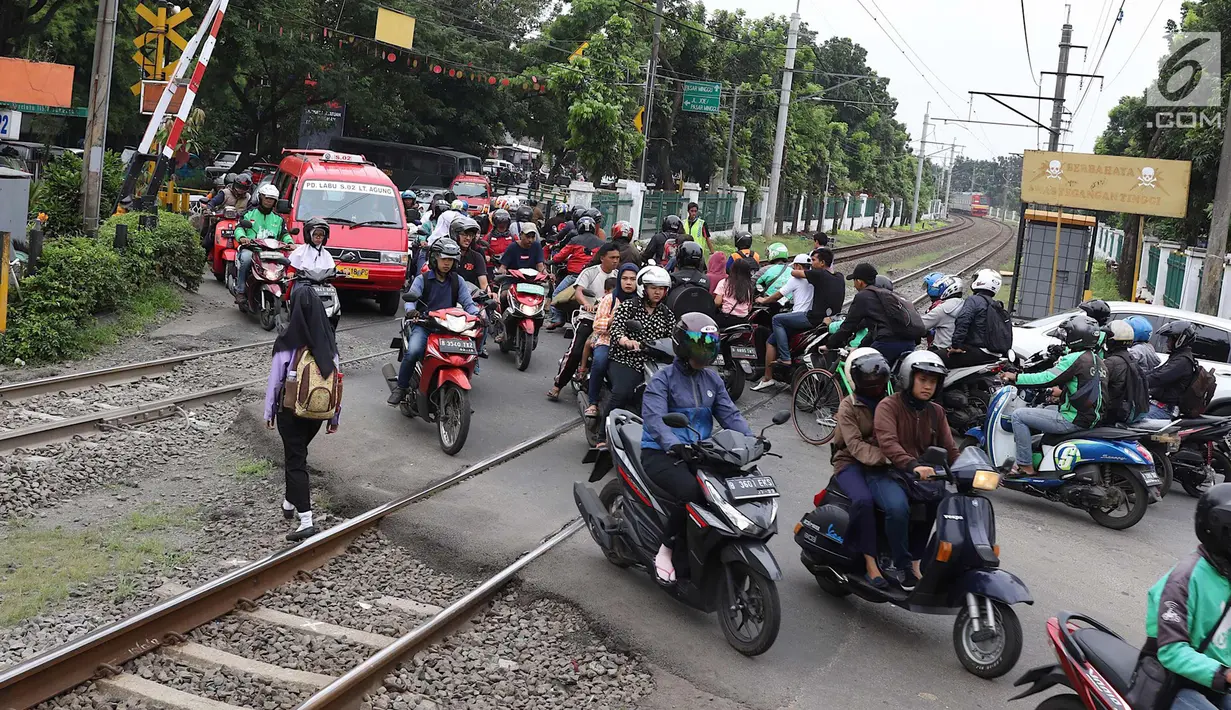Kendaraan menyeberangi perlintasan kereta api di Lenteng Agung, Jakarta, Selasa (13/3). Untuk mengurai kemacetan imbas antrian kendaraan berputar balik di pintu kereta IISIP, Pemprov DKI berencana membangun flyover U-Turn. (Liputan6.com/Immanuel Antonius)